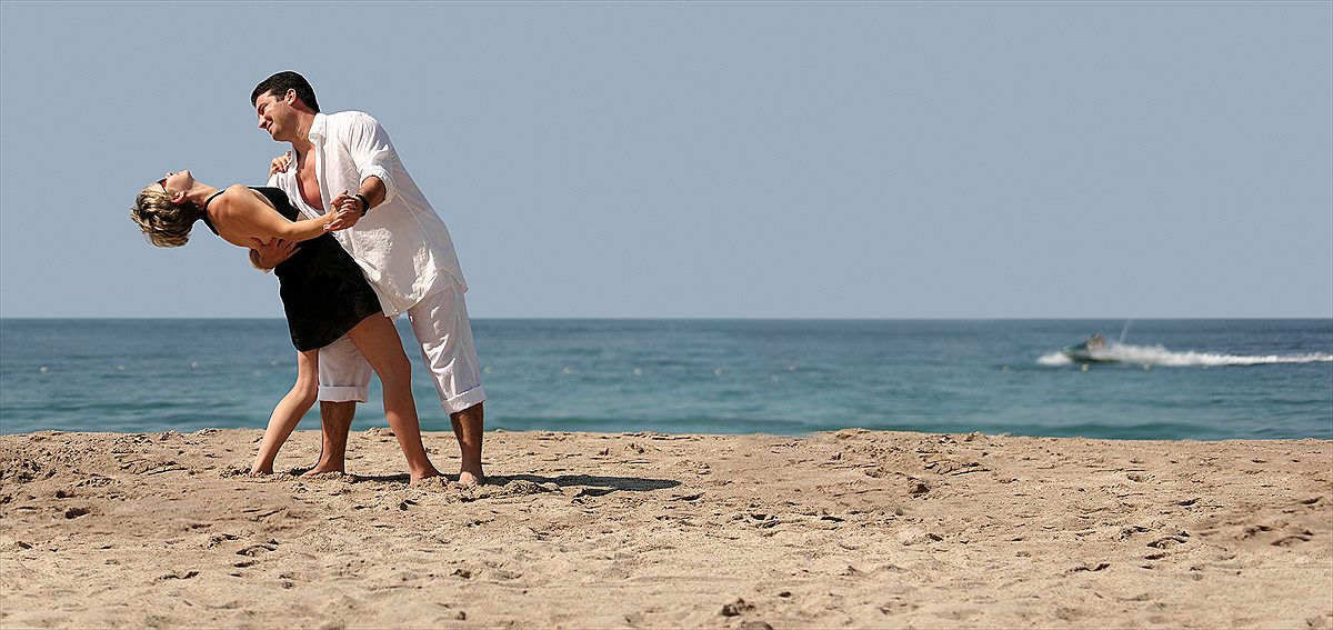 Mature couple enjoying a beach vacation at sunset